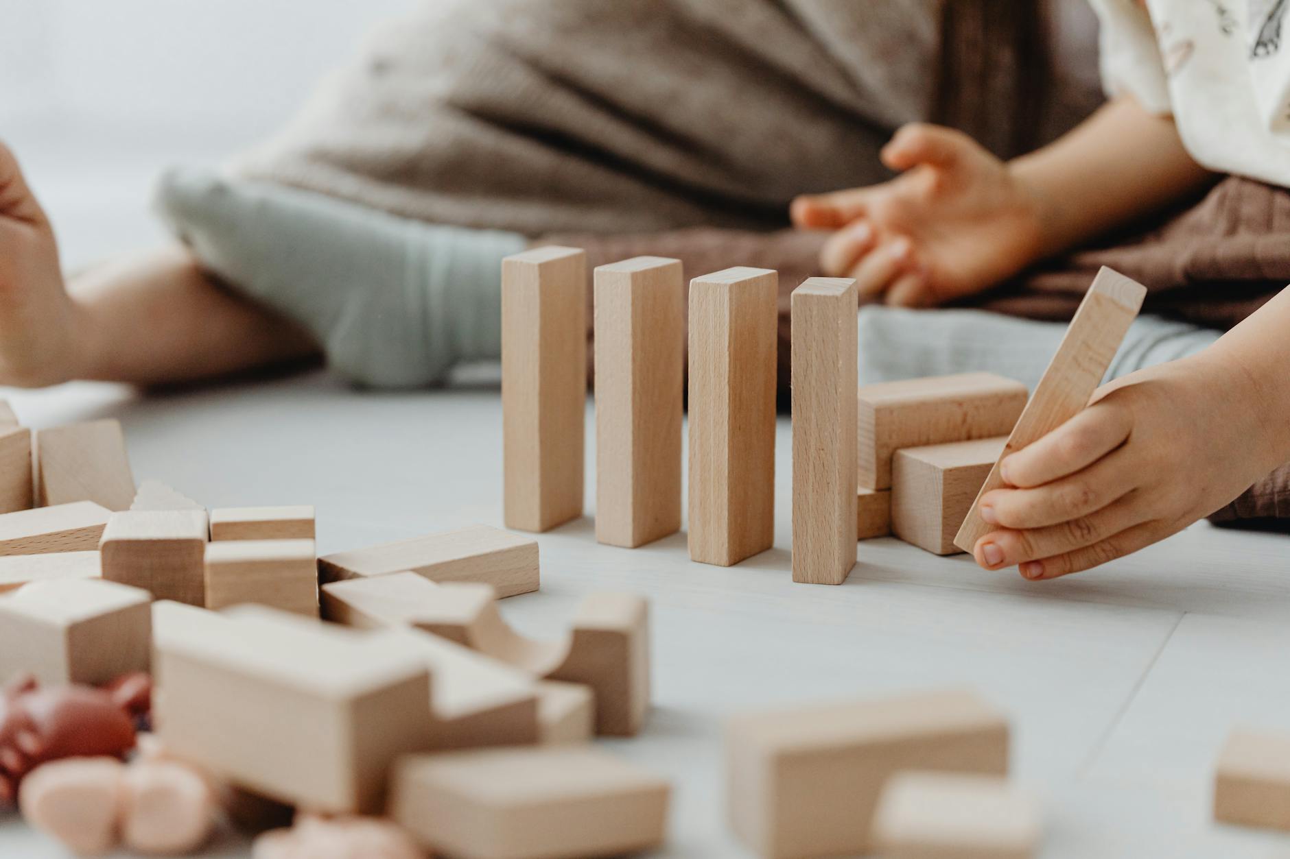 photo of a kid s hand placing a wooden block